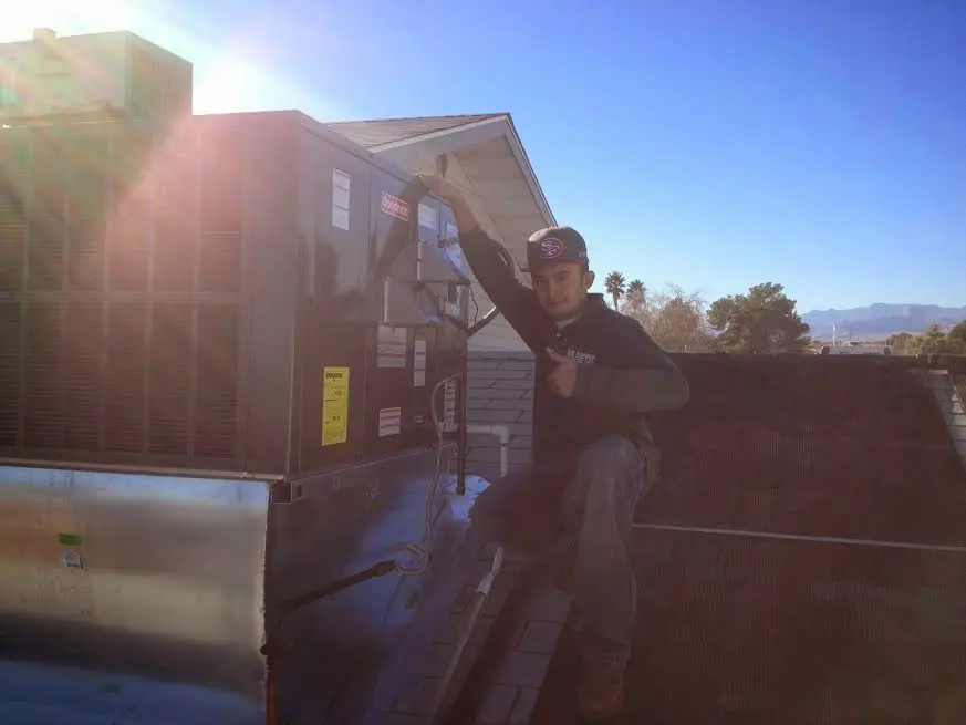 HVAC technician performing Boiler Repair on a rooftop unit in Falls Church